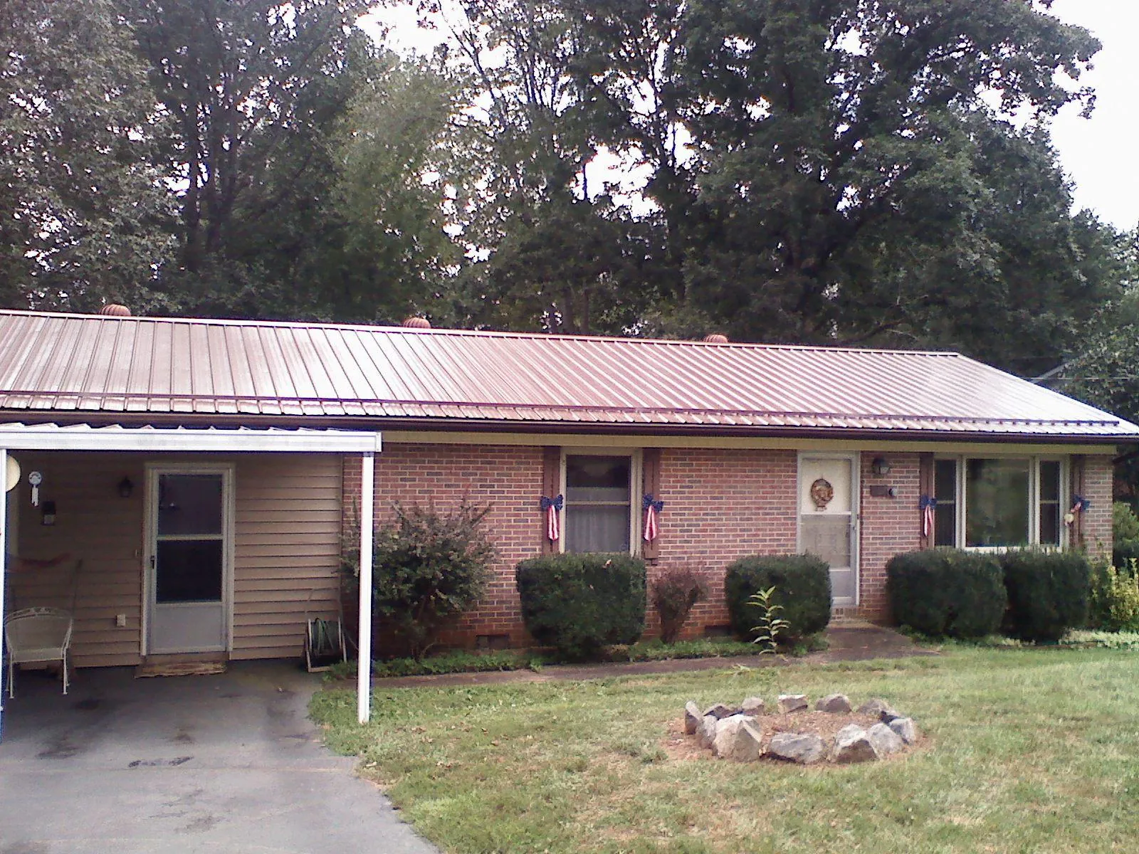 Bronze metal roof and carport on a brick ranch home — Roof Repair work by our crew in Cascade